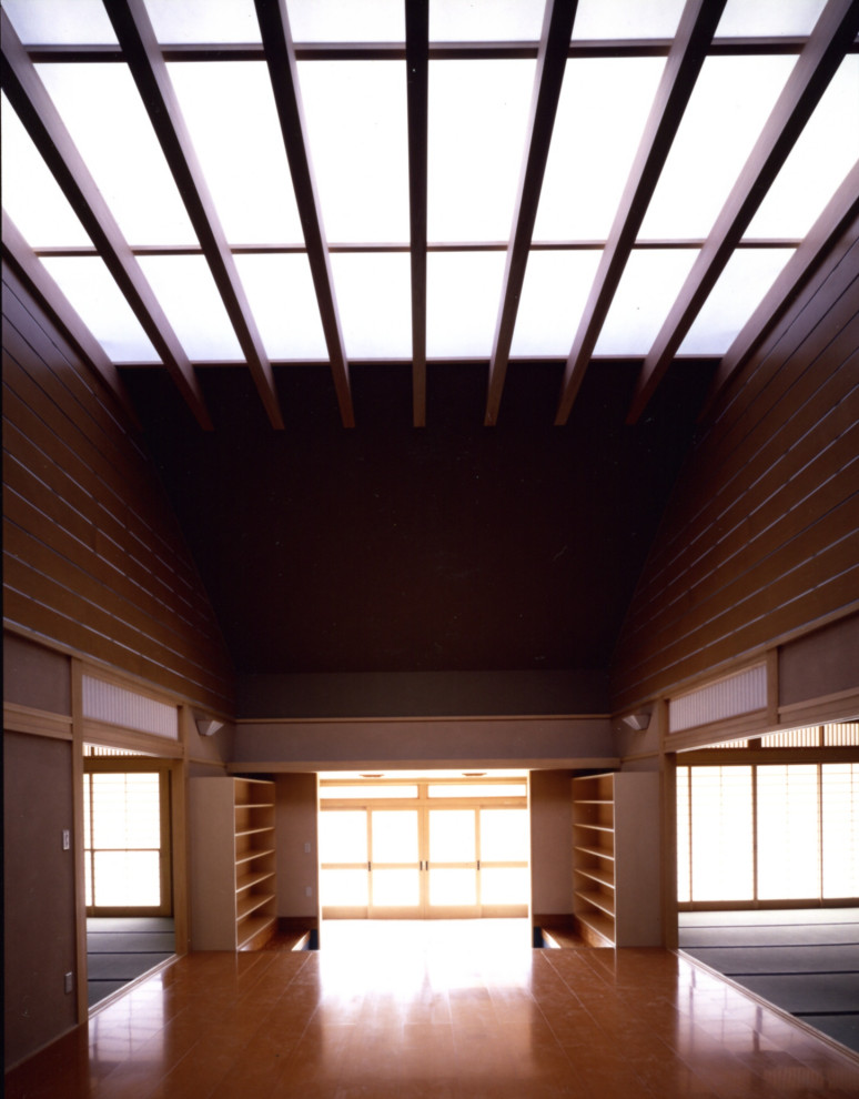 Bild på en stor orientalisk hall, med bruna väggar, ljust trägolv, en skjutdörr, ljus trädörr och brunt golv