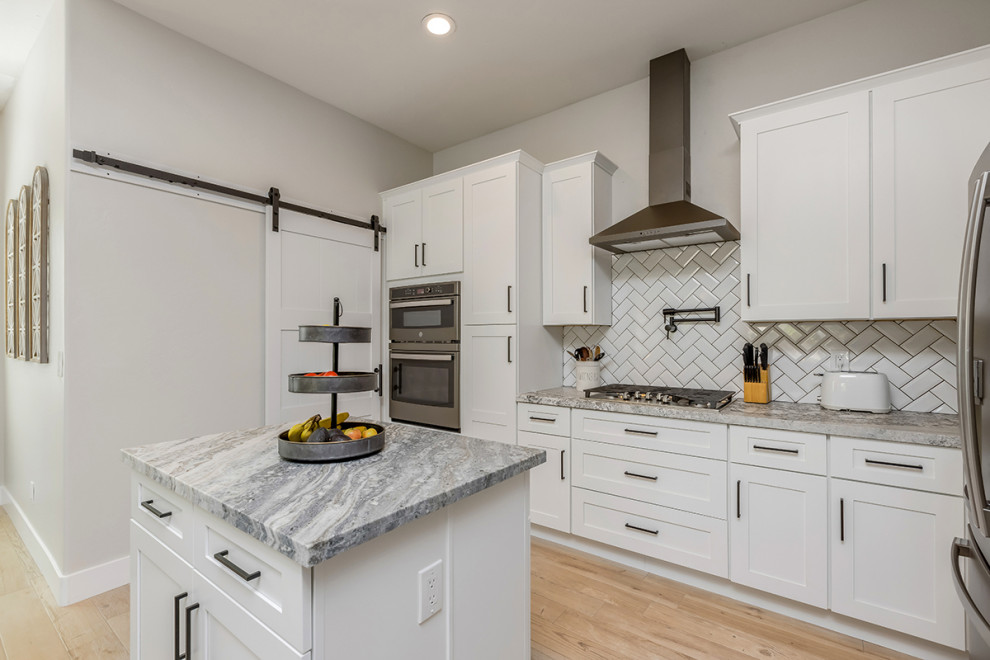 Bild på ett mellanstort vintage vit linjärt vitt kök och matrum, med en undermonterad diskho, skåp i shakerstil, vita skåp, granitbänkskiva, vitt stänkskydd, stänkskydd i keramik, rostfria vitvaror, klinkergolv i porslin, flera köksöar och brunt golv