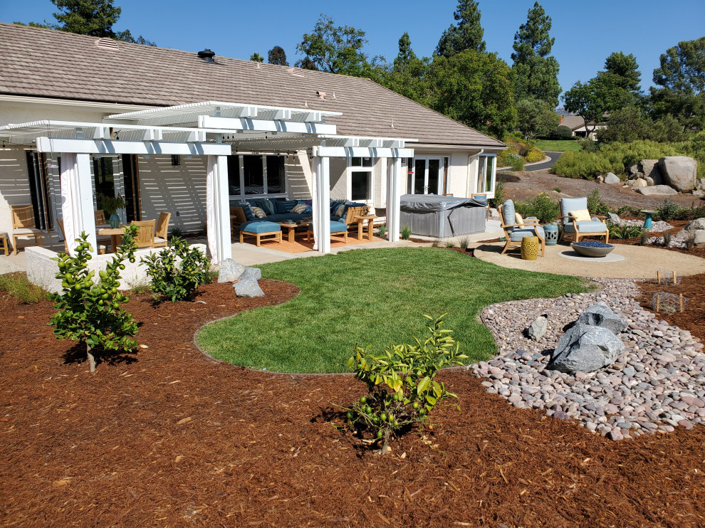 Ejemplo de jardín de secano ecléctico de tamaño medio en verano en patio trasero con paisajismo estilo desértico, exposición total al sol y adoquines de piedra natural