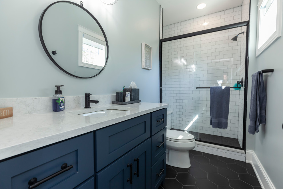Country 3/4 bathroom in Chicago with blue cabinets, an open shower, a one-piece toilet, blue walls, ceramic floors, black floor, white benchtops, a single vanity and a built-in vanity.