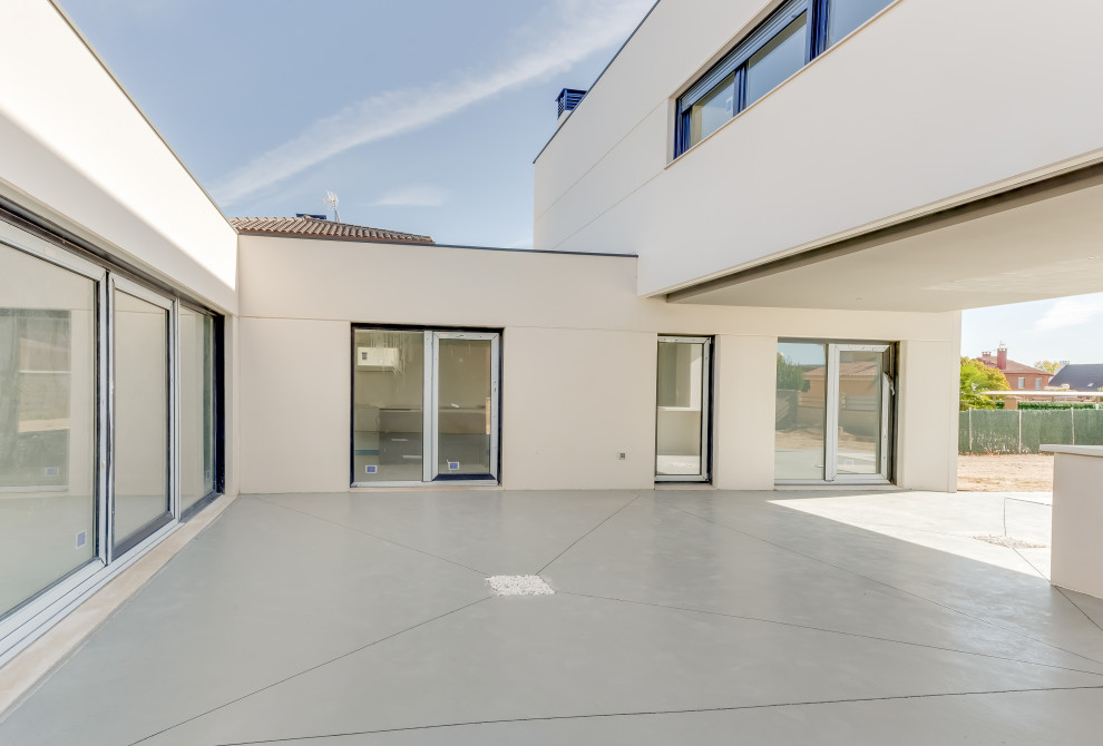 Modelo de patio actual de tamaño medio en patio delantero con losas de hormigón