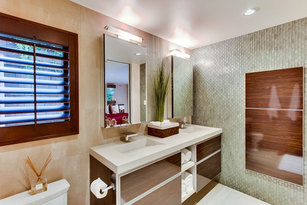 Ispirazione per una stanza da bagno padronale design di medie dimensioni con ante lisce, ante in legno scuro, WC monopezzo, pareti beige e lavabo integrato