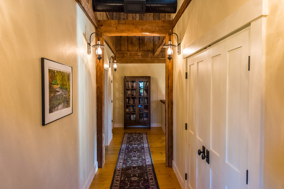 Expansive country hallway in Boston with beige walls and light hardwood floors.