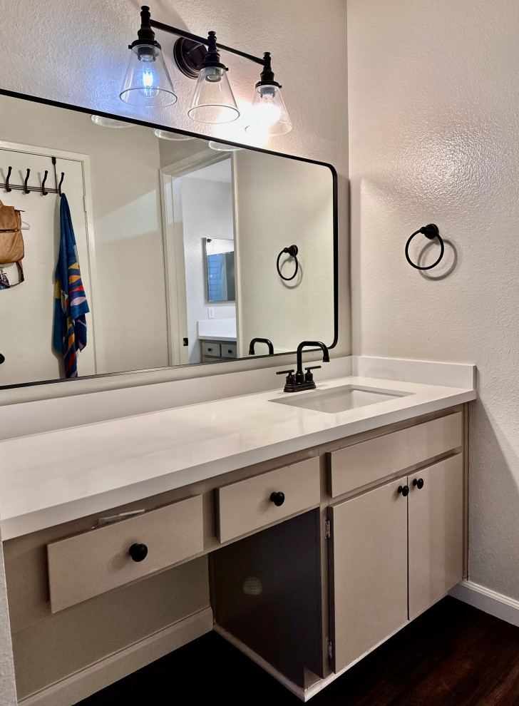 This is an example of a medium sized classic bathroom in Los Angeles with flat-panel cabinets, beige cabinets, a freestanding bath, a shower/bath combination, a one-piece toilet, white tiles, ceramic tiles, grey walls, vinyl flooring, a submerged sink, engineered stone worktops, brown floors, a shower curtain, white worktops, a wall niche, a single sink and a freestanding vanity unit.