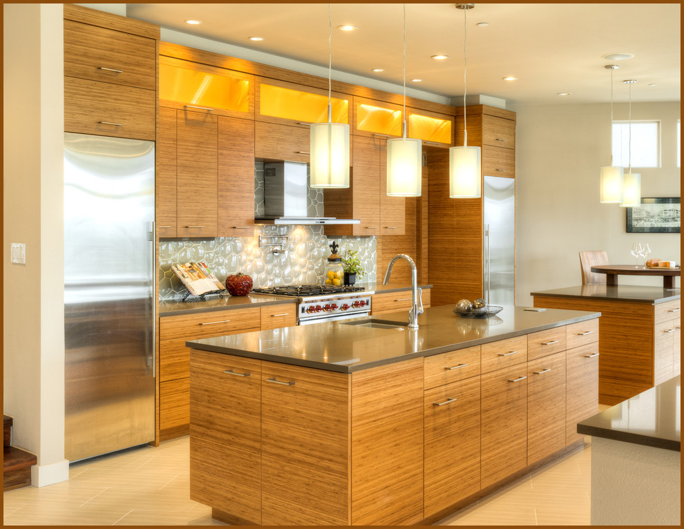 Large contemporary eat-in kitchen in Seattle with flat-panel cabinets, light wood cabinets, limestone benchtops, glass tile splashback, stainless steel appliances, porcelain floors, multiple islands, an undermount sink, grey splashback, beige floor and grey benchtop.