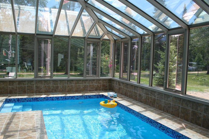 This is an example of a large sunroom in Other with a glass ceiling.