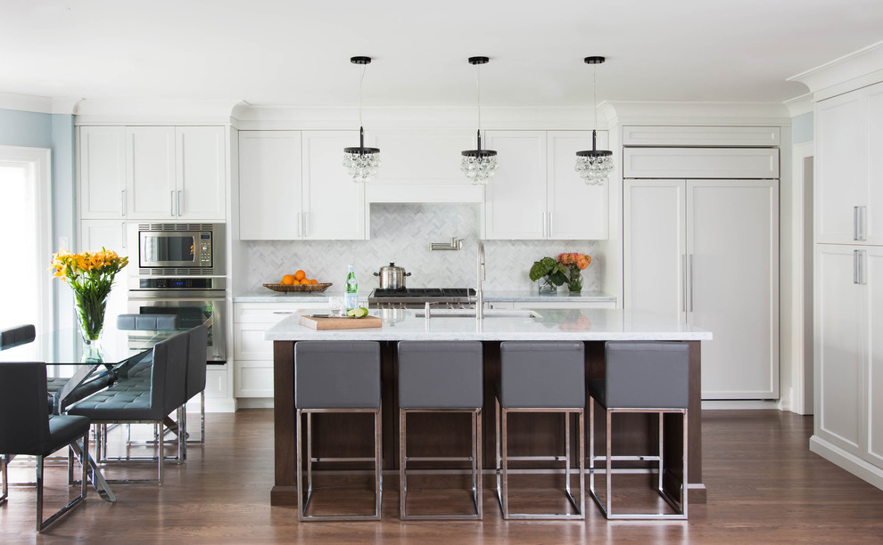 Photo of a transitional l-shaped eat-in kitchen in Toronto with an undermount sink, shaker cabinets, white cabinets, white splashback, stainless steel appliances, dark hardwood floors and with island.