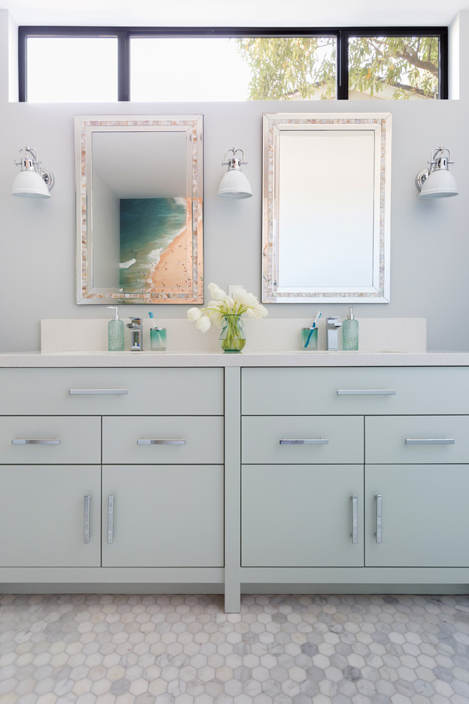 Photo of a mid-sized contemporary 3/4 bathroom in Los Angeles with flat-panel cabinets, grey cabinets, white tile, marble, an undermount sink, solid surface benchtops, white benchtops, grey walls, a shower curtain, a shower/bathtub combo, marble floors and white floor.
