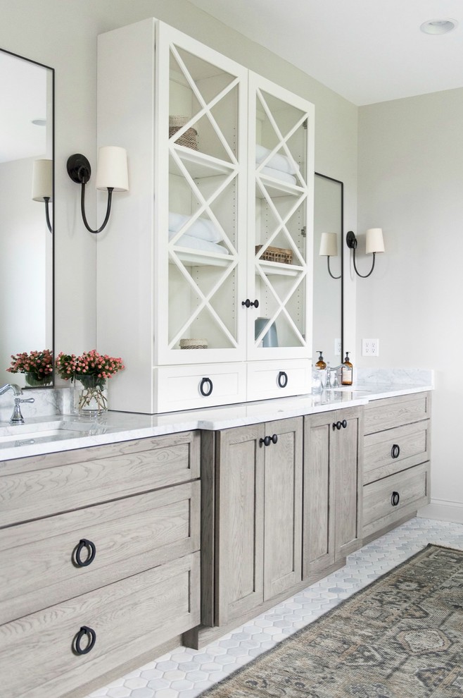 Example of a large transitional master white tile and subway tile marble floor and white floor freestanding bathtub design in Indianapolis with shaker cabinets, medium tone wood cabinets, a one-piece toilet, white walls, an undermount sink, marble countertops and a hinged shower door
