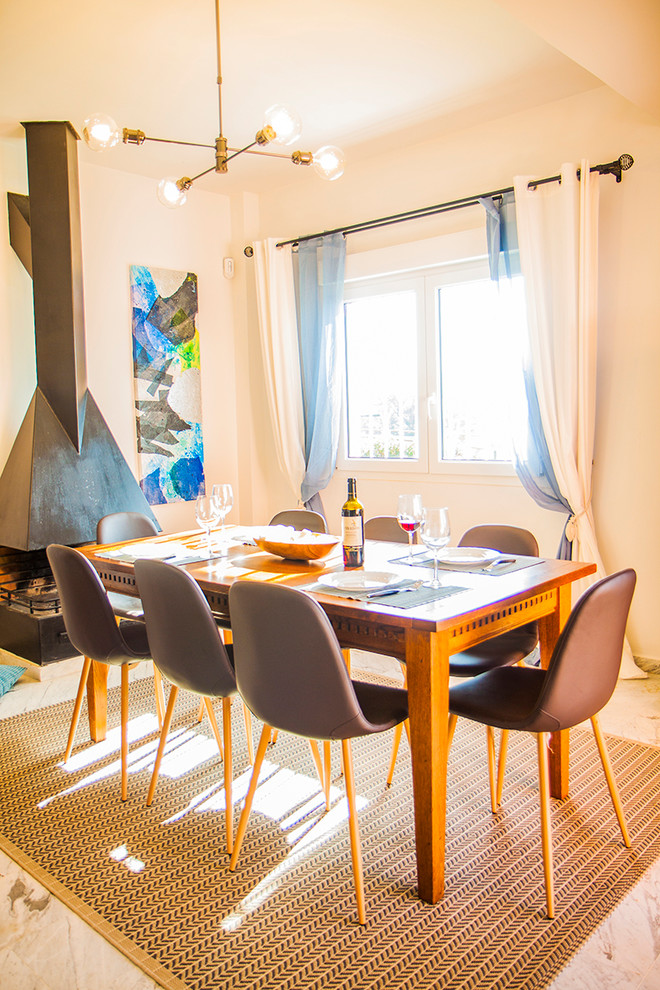Diseño de comedor marinero de tamaño medio abierto con paredes beige, suelo de mármol, todas las chimeneas y suelo blanco