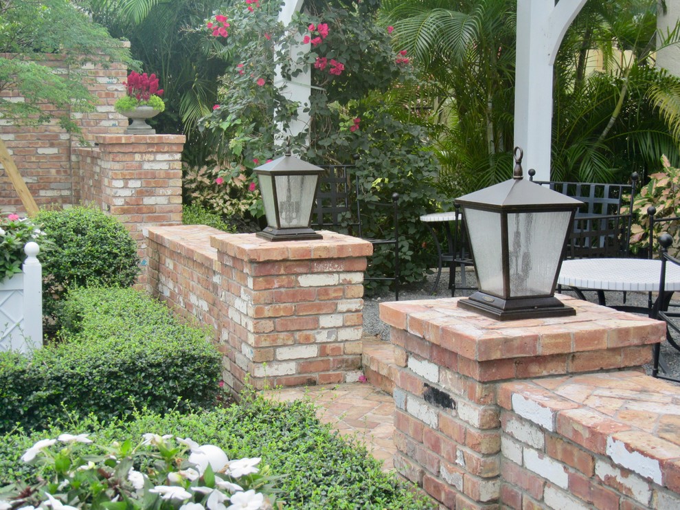 Design ideas for a traditional courtyard formal garden in Miami with a garden path and brick pavers.