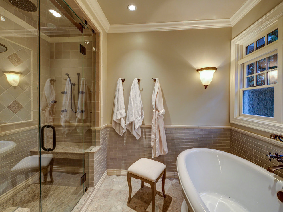 This is an example of a traditional bathroom in Charlotte with a freestanding tub, beige tile and with a sauna.