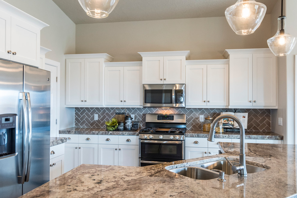 Photo of a large traditional l-shaped open plan kitchen in Salt Lake City with a double-bowl sink, shaker cabinets, white cabinets, granite benchtops, brown splashback, ceramic splashback, stainless steel appliances, dark hardwood floors and with island.