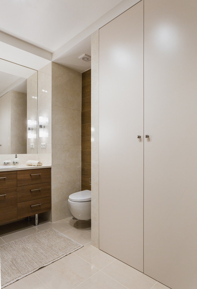 Photo of a mid-sized contemporary master bathroom in Moscow with flat-panel cabinets, medium wood cabinets, an alcove tub, a shower/bathtub combo, a wall-mount toilet, beige tile, ceramic tile, beige walls, porcelain floors, a drop-in sink and solid surface benchtops.