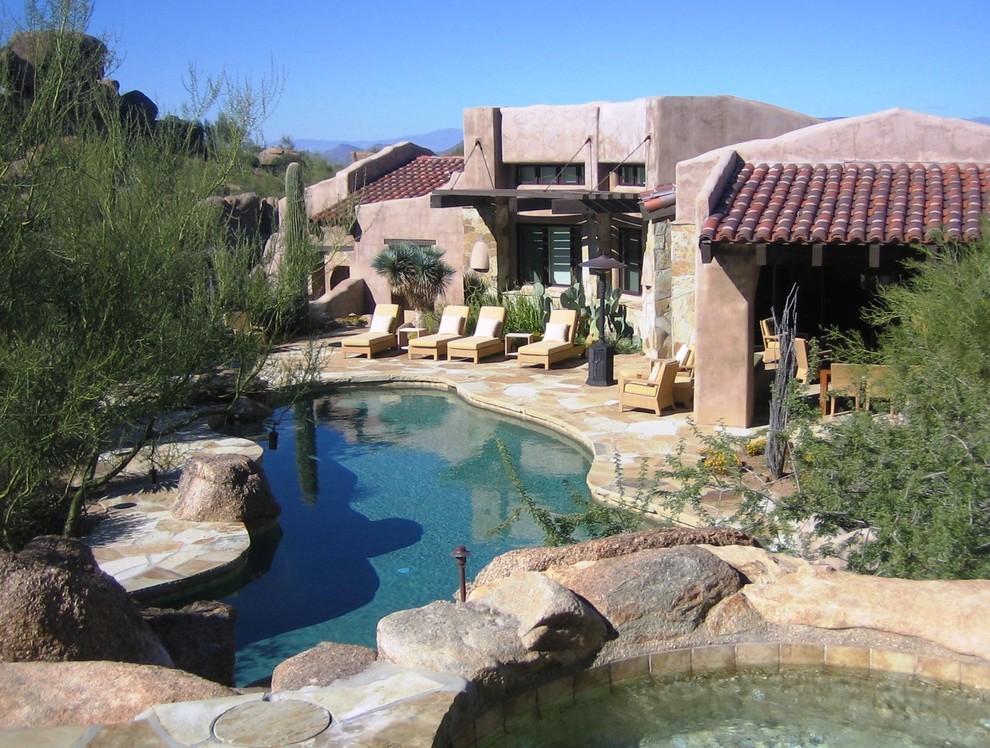 Mediterranean custom-shaped pool in Phoenix with natural stone pavers.