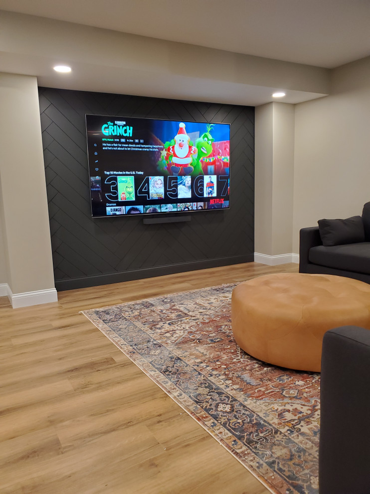 This is an example of a large traditional walk-out basement in Cincinnati with a home bar, beige walls, laminate floors, brown floors and tongue and groove walls.