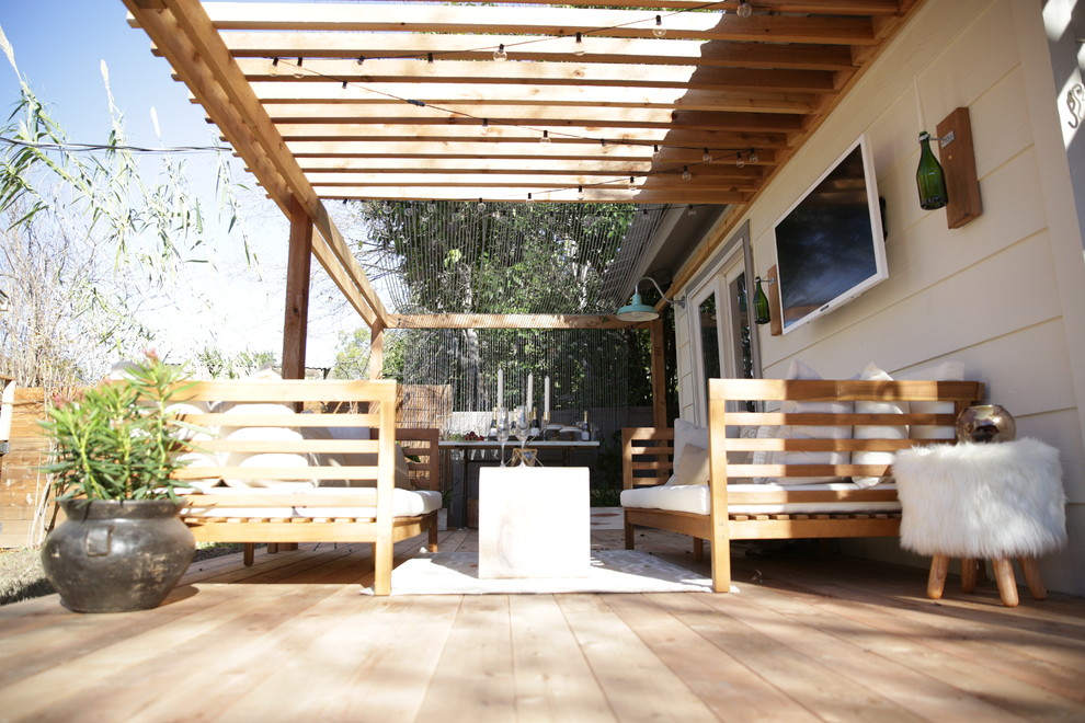 Small cottage chic backyard deck photo in Austin with a pergola