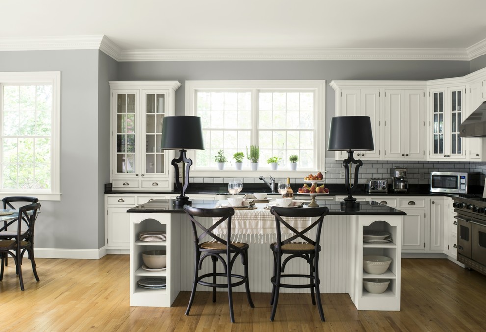 Inspiration for an eat-in kitchen remodel in New York with an island and black countertops