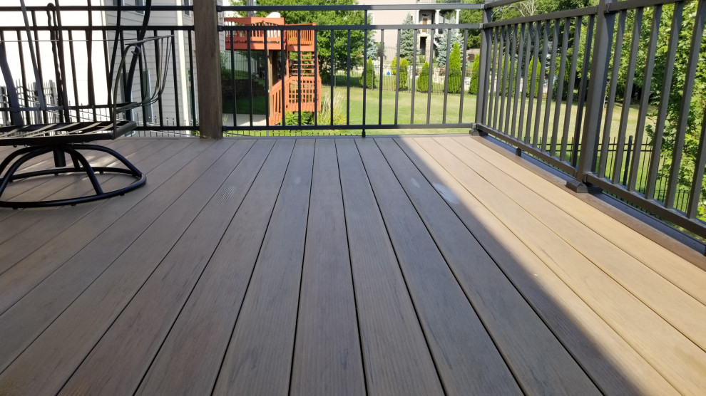 Deck - mid-sized backyard second story privacy and metal railing deck idea with a roof extension
