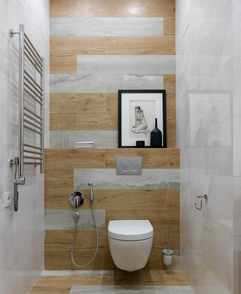 This is an example of a mid-sized contemporary powder room in Moscow with a wall-mount toilet, porcelain tile and porcelain floors.