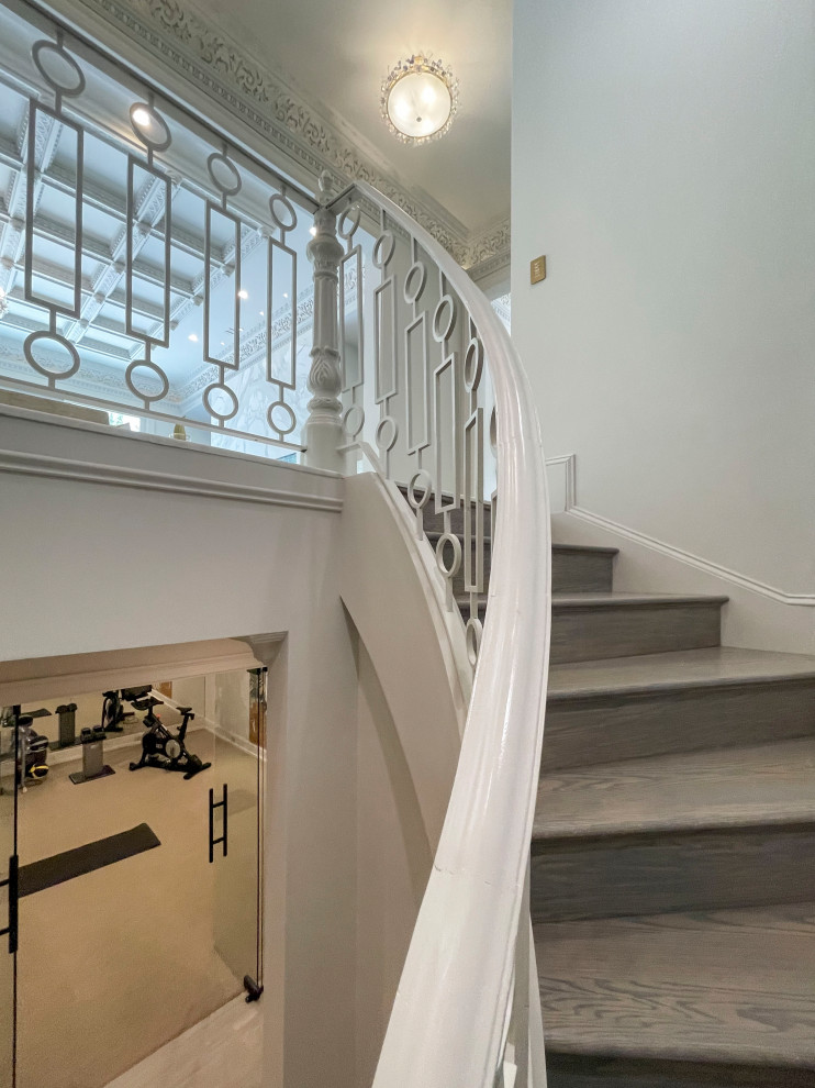 Inspiration for an expansive traditional wood floating metal railing staircase in DC Metro with wood risers and panelled walls.