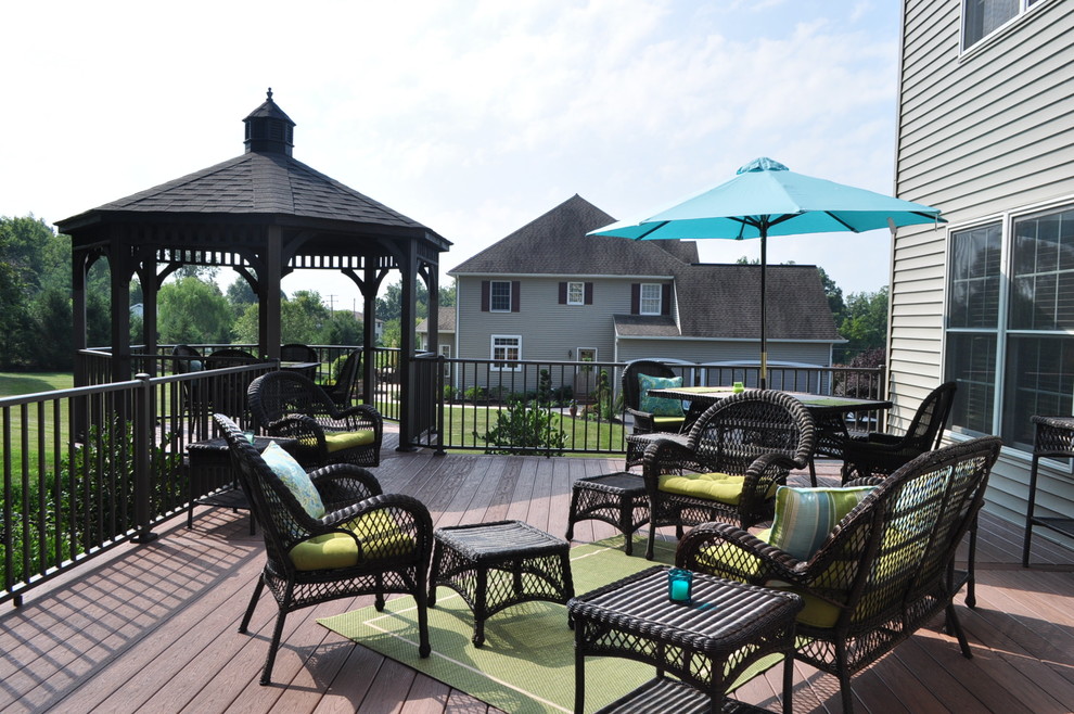 Example of a mid-sized transitional backyard deck design with a pergola