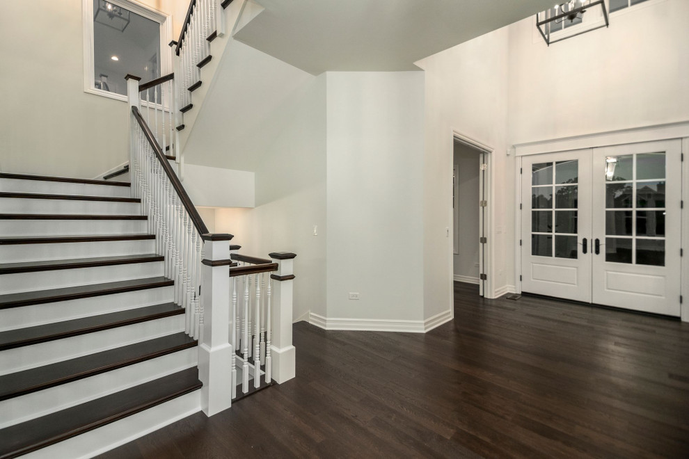 Foyer - large brown floor foyer idea in Chicago with white walls and a white front door
