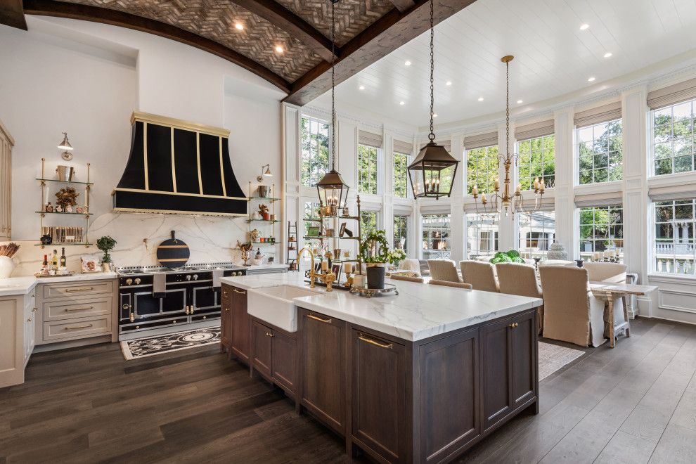 Photo of a l-shaped eat-in kitchen in San Francisco with a farmhouse sink, beaded inset cabinets, grey cabinets, white splashback, stone slab splashback, black appliances, dark hardwood floors, with island, brown floor, white benchtop and vaulted.