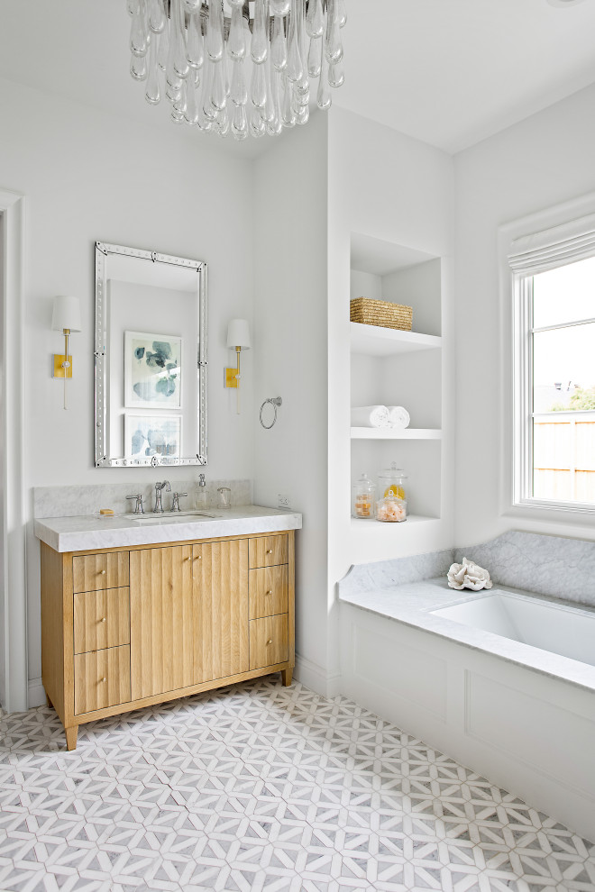 Idéer för att renovera ett stort vintage vit vitt en-suite badrum, med möbel-liknande, skåp i ljust trä, ett undermonterat badkar, en kantlös dusch, en toalettstol med separat cisternkåpa, vit kakel, marmorkakel, vita väggar, ljust trägolv, ett undermonterad handfat, marmorbänkskiva, brunt golv och dusch med gångjärnsdörr