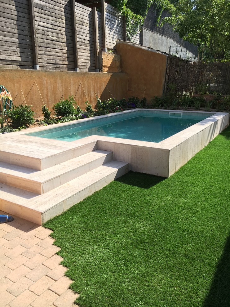 Photo of a small courtyard custom-shaped aboveground pool in Barcelona with concrete pavers.