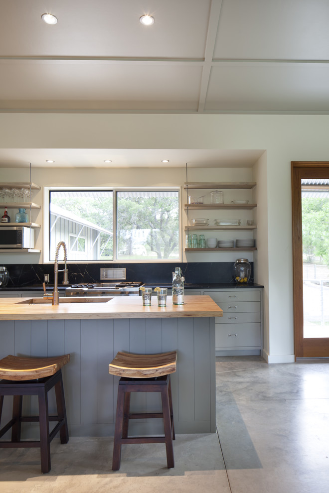 Photo of a modern kitchen in Austin with wood benchtops and grey cabinets.