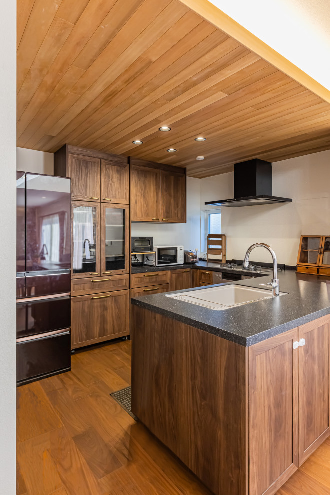 Aménagement d'une cuisine ouverte moderne en U et bois foncé de taille moyenne avec parquet foncé, un sol marron, plan de travail noir et un plafond en papier peint.