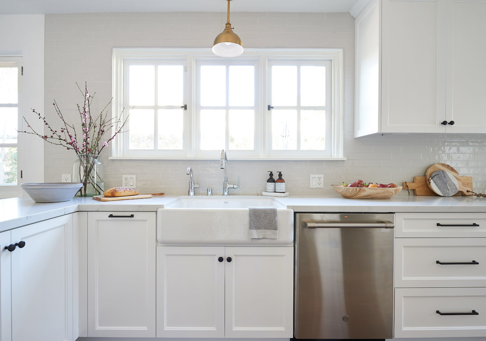 Inspiration for a mid-sized beach style galley eat-in kitchen in San Diego with an undermount sink, shaker cabinets, white cabinets, quartz benchtops, grey splashback, ceramic splashback, stainless steel appliances, medium hardwood floors, with island, brown floor and white benchtop.
