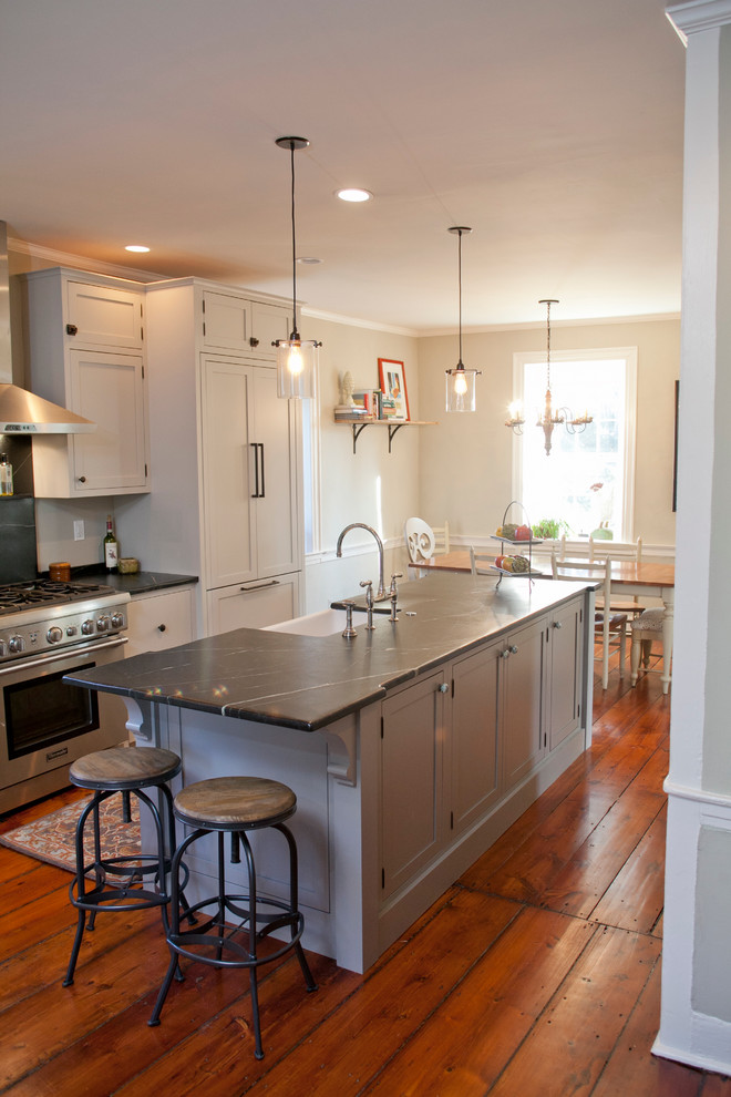Inspiration for a large country galley eat-in kitchen in Philadelphia with a farmhouse sink, shaker cabinets, grey cabinets, soapstone benchtops, stainless steel appliances, medium hardwood floors and with island.
