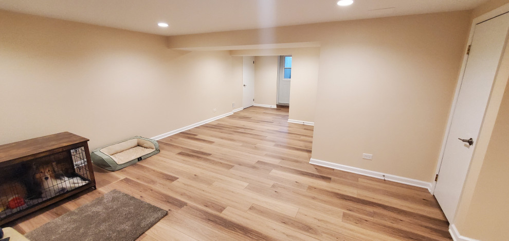 Fully remodeled 1970s finished basement with luxury vinyl plank flooring and can