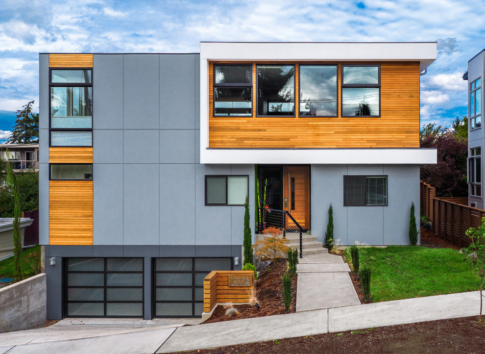 Inspiration for a mid-sized contemporary two-storey house exterior in Seattle with concrete fiberboard siding and a flat roof.