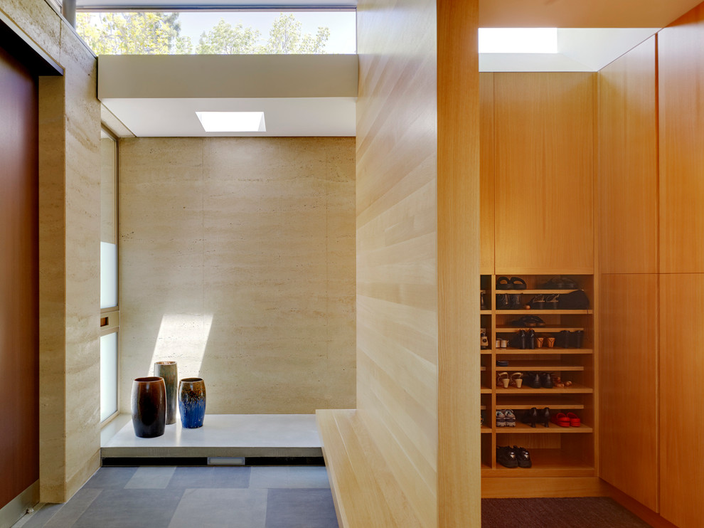 This is an example of a mid-sized modern mudroom in San Francisco with beige walls and a light wood front door.