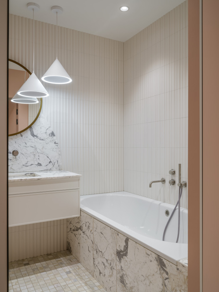Inspiration för mellanstora beige en-suite badrum, med luckor med upphöjd panel, beige skåp, ett undermonterat badkar, en vägghängd toalettstol, beige kakel, keramikplattor, rosa väggar, marmorgolv, ett undermonterad handfat, marmorbänkskiva och grått golv
