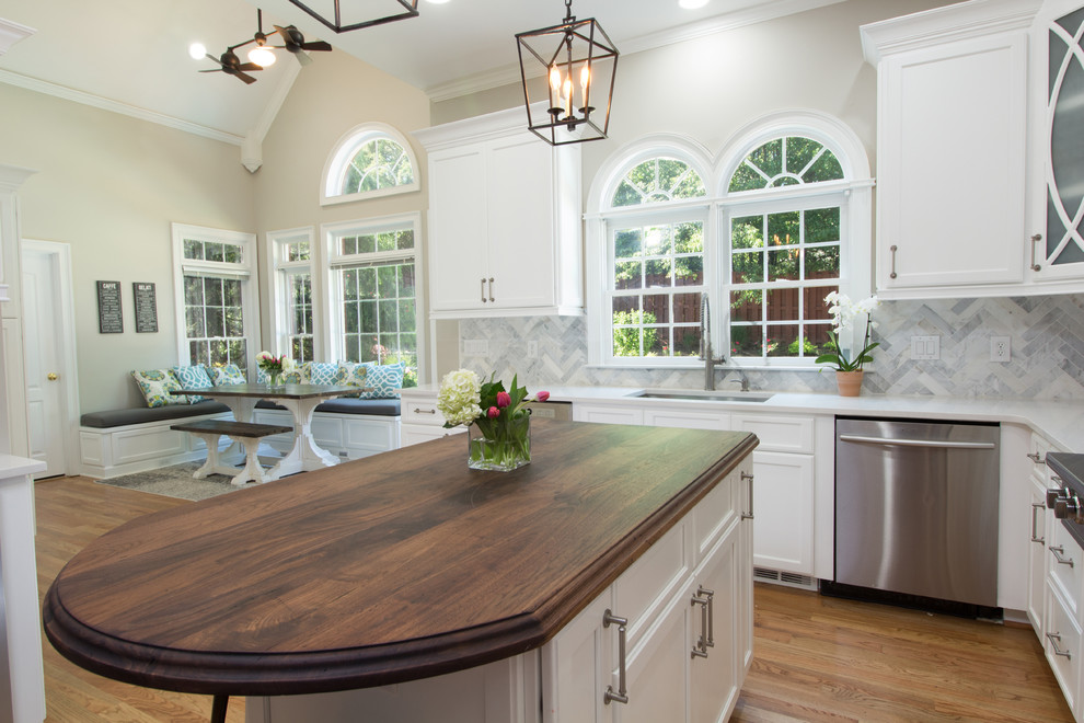 Eat-in kitchen - mid-sized transitional l-shaped medium tone wood floor eat-in kitchen idea in Atlanta with an undermount sink, shaker cabinets, white cabinets, quartzite countertops, white backsplash, stone tile backsplash, stainless steel appliances and an island