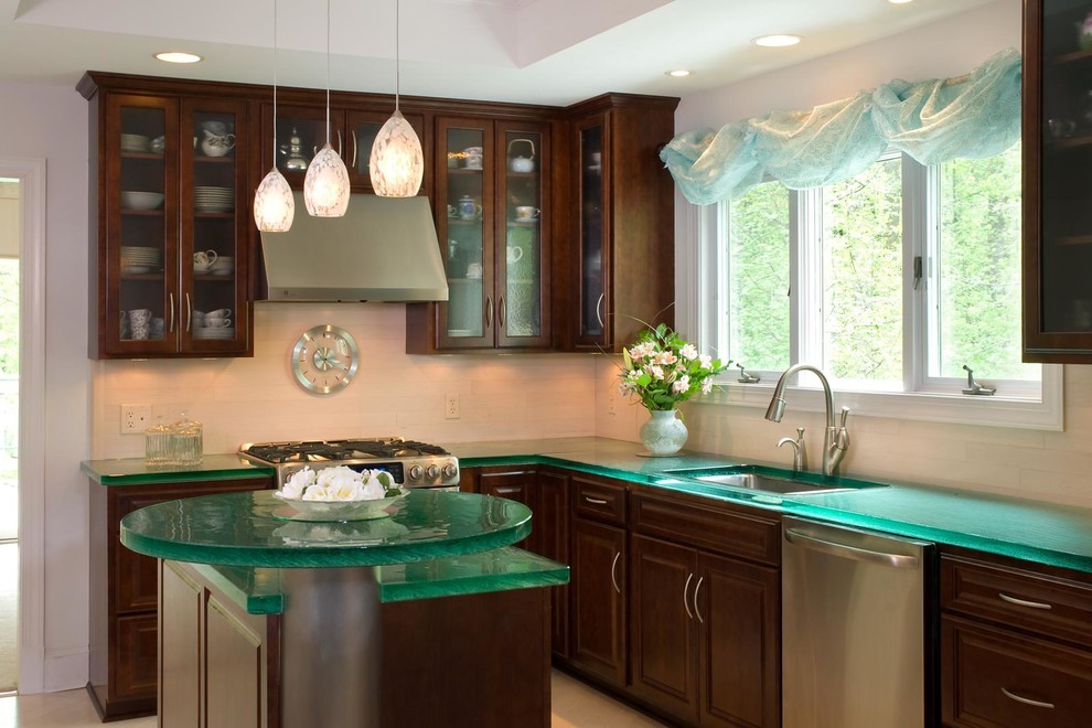 Photo of a contemporary l-shaped eat-in kitchen in Orlando with a drop-in sink, medium wood cabinets, stainless steel appliances, with island, glass-front cabinets, glass benchtops and green benchtop.