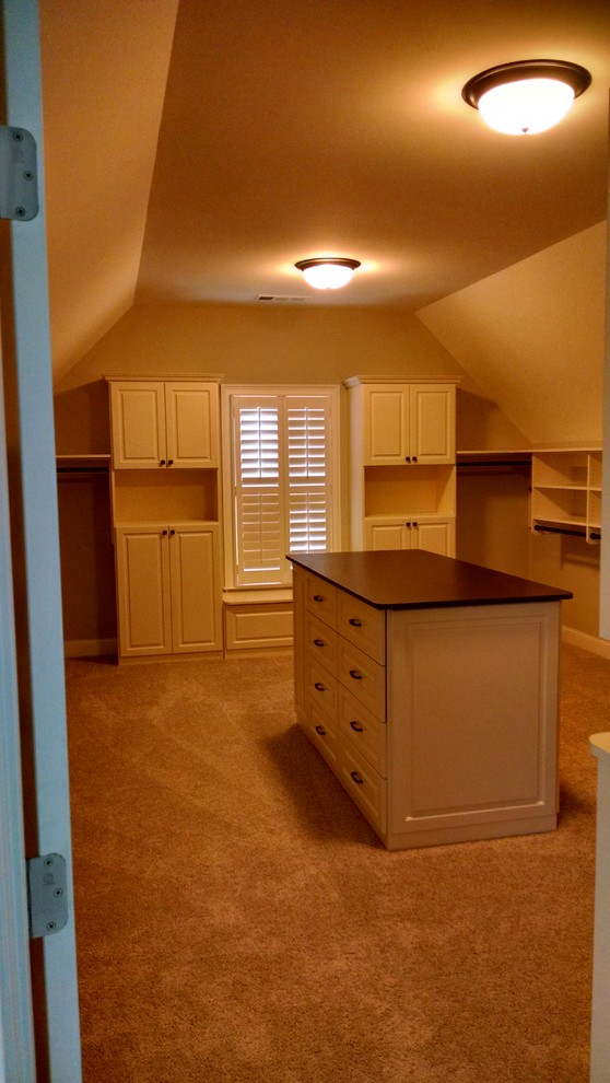 Photo of a mid-sized traditional gender-neutral walk-in wardrobe in Atlanta with raised-panel cabinets, white cabinets and carpet.