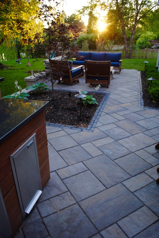 This is an example of a contemporary backyard partial sun garden in Indianapolis with a fire feature and concrete pavers.