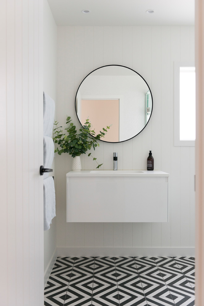 Design ideas for a contemporary bathroom in Auckland with flat-panel cabinets, white cabinets, white walls, multi-coloured floor, white benchtops and planked wall panelling.