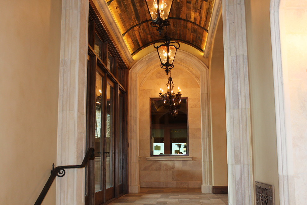This is an example of a mid-sized mediterranean hallway in Phoenix with beige walls, travertine floors and beige floor.