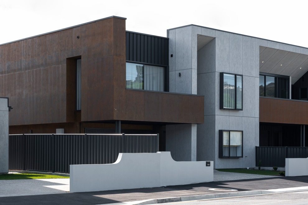 Inspiration pour une façade de maison de ville noire urbaine en béton et planches et couvre-joints de taille moyenne et à un étage avec un toit plat, un toit en métal et un toit noir.