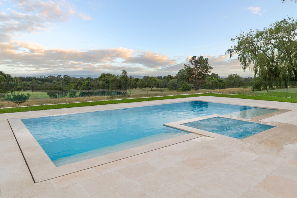 Inspiration for a modern backyard custom-shaped pool in Gold Coast - Tweed with natural stone pavers.
