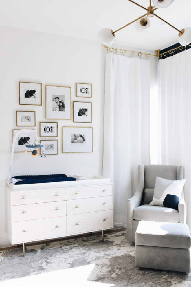 Idée de décoration pour une chambre de bébé garçon minimaliste de taille moyenne avec un mur bleu, un sol en bois brun et un sol beige.