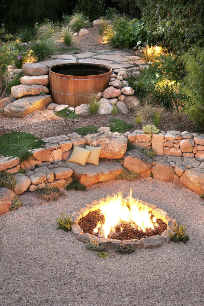Large contemporary backyard partial sun xeriscape in Santa Barbara with a fire feature and gravel.