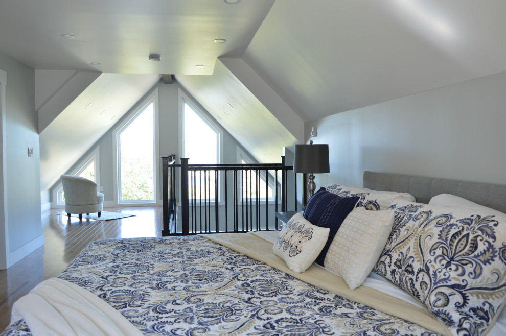 Photo of a beach style loft-style bedroom in Other with grey walls, light hardwood floors, beige floor and vaulted.