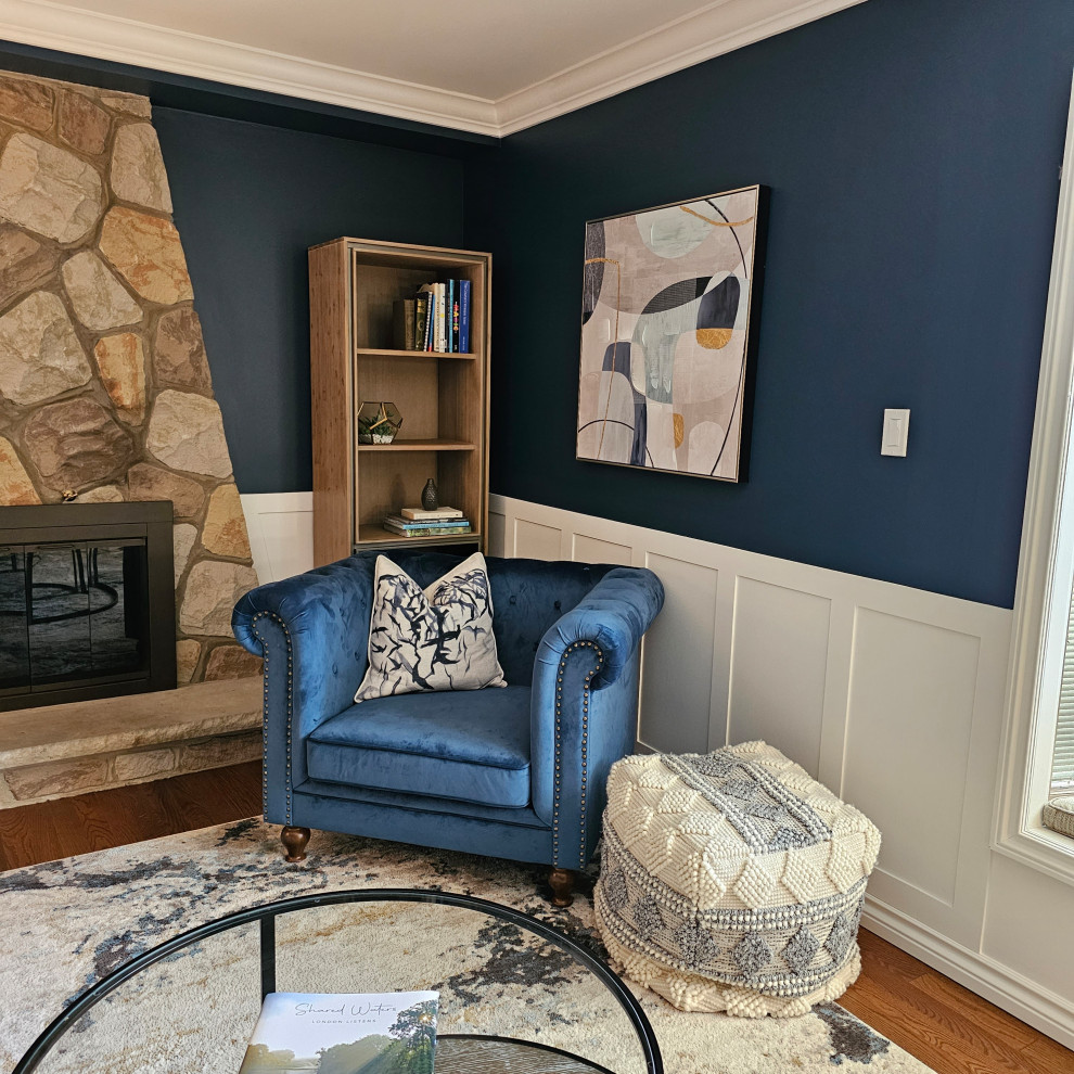Idée de décoration pour un salon vintage fermé avec un mur bleu, un sol en bois brun et boiseries.